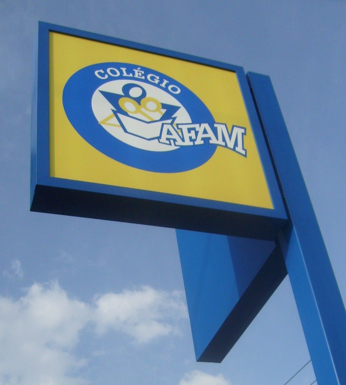 Totem luminoso azul e amarelo do Colégio AFAM contra céu aberto