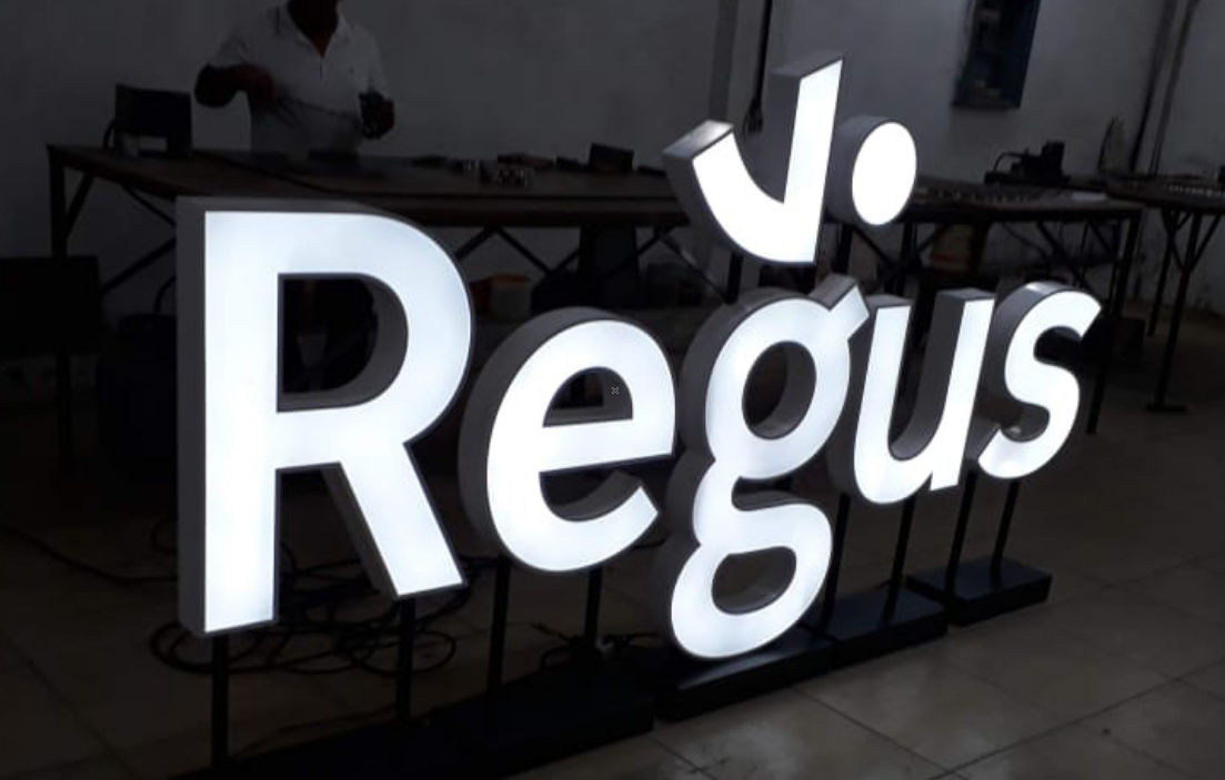 Letras caixa Regus em volume branco com iluminação interna LED, testadas na fábrica antes da instalação