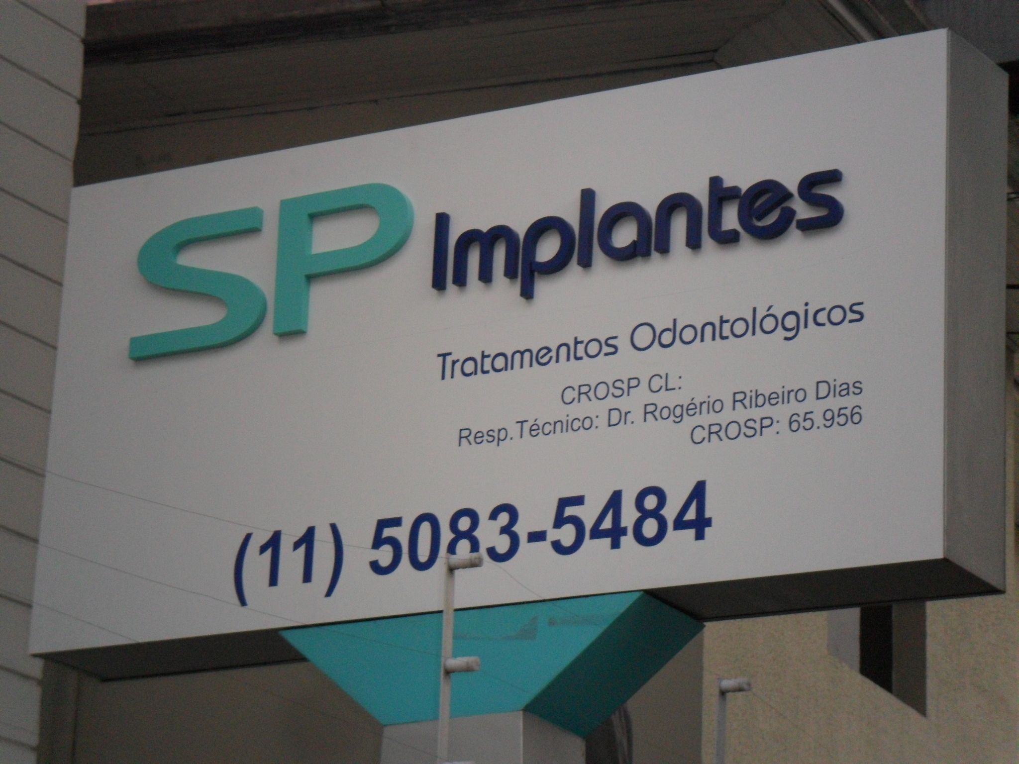 Caixa luminosa branca da clínica SP Implantes instalada em fachada comercial